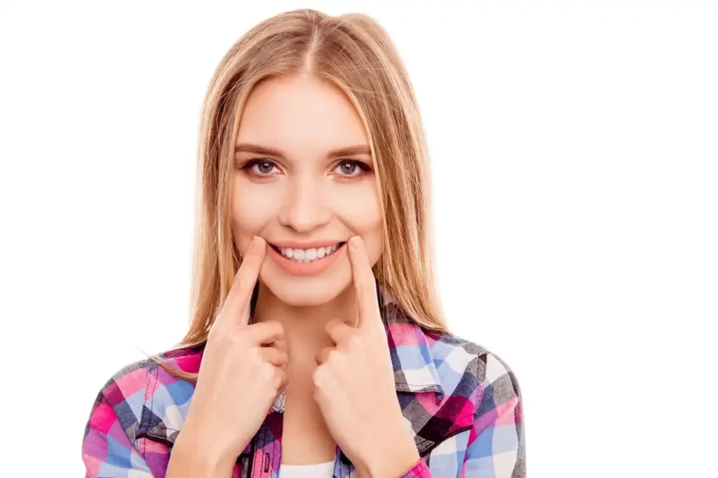 Woman demonstrates potential results of Botox lip corner lifts for a youthful smile.