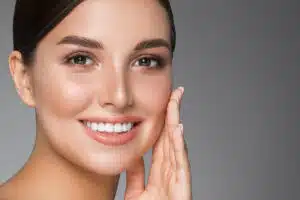 Radiant woman touching face, showcasing Botox benefits for smooth skin.