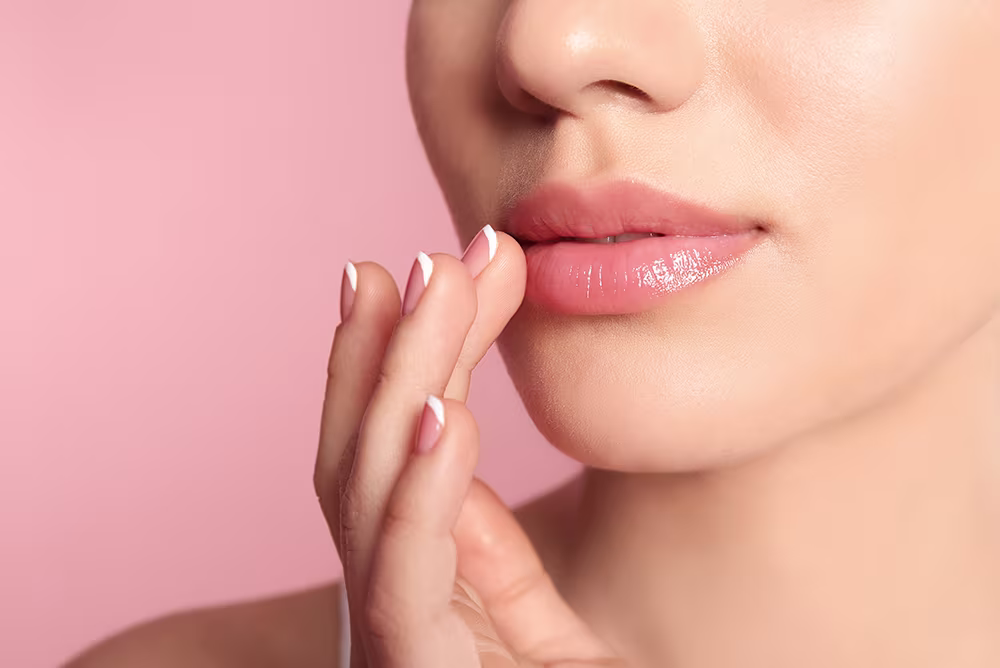 Close-up of full, contoured lips with soft pink background, illustrating lip lift surgical enhancement results